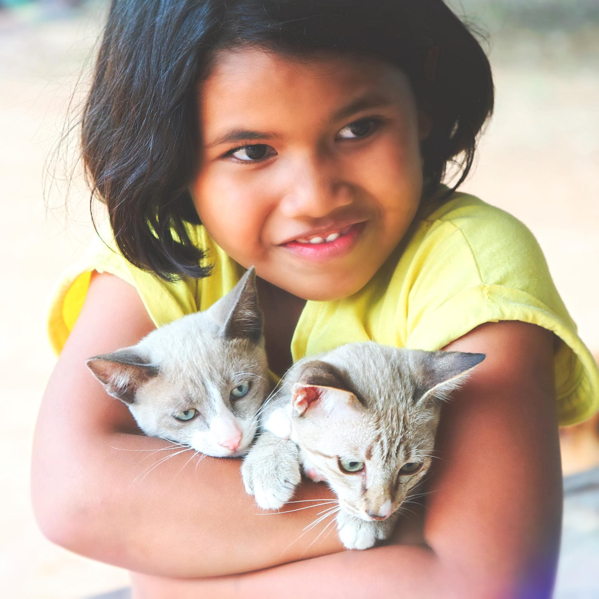Two young smiling children hugging each other